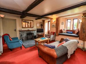 a living room with a couch and a fireplace at Tethera Cottage in Penrith