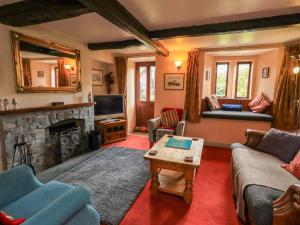 a living room with a couch and a fireplace at Tethera Cottage in Penrith