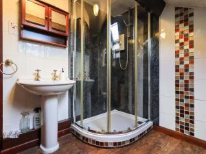 a bathroom with a shower and a sink at Tethera Cottage in Penrith +30 photos