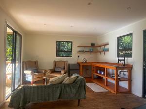 a living room with a couch and a desk at FireFly Starry Woods Cabin in Keurboomstrand