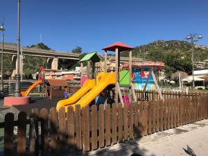 a playground behind a wooden fence at Mareluce in Letojanni