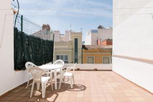 a balcony with a table and chairs on a roof at Casa 2 Hab con Terraza & Barbacoa en Ubicación Céntrica in Gandía