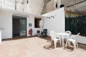 a patio with a white table and chairs at Casa 2 Hab con Terraza & Barbacoa en Ubicación Céntrica in Gandía