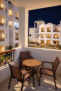 a table and chairs on a balcony with a building at Arian North Coast Chalet Santorini Resort El Alamein in El Alamein