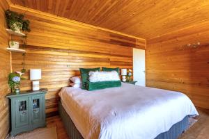 a bedroom with a bed with a wooden wall at Summer Villa in Mossel Bay