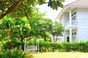 a white bench in a yard next to a house at Vila Mũi Né-Phan Thiết in Ấp Ngọc Hải