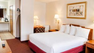 a hotel room with a bed and a kitchen at Tava Motel Manitou Springs in Manitou Springs +20 photos