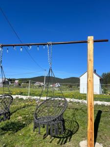 two swings in a yard with a field of flowers at Everpine house in Žabljak