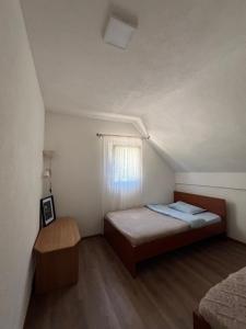 a small bedroom with a bed and a window at Everpine house in Žabljak