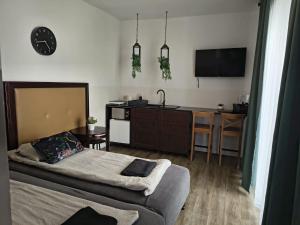 a bedroom with a bed and a kitchen with a table at Flores Apartament in Katowice +14 photos