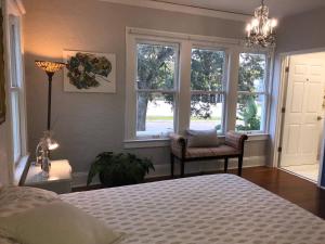 a bedroom with a bed and two windows and a chair at Comfy and Spacious Suite with Free Parking in Miami +71 photos