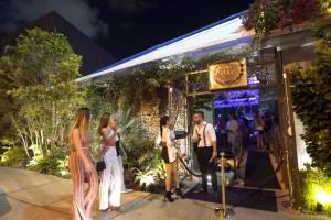 a group of people standing outside of a restaurant at night at Comfy and Spacious Suite with Free Parking in Miami