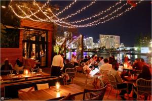 a group of people sitting at a restaurant with lights at Comfy and Spacious Suite with Free Parking in Miami