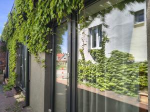 a glass door of a building with plants at Flores Apartament in Katowice