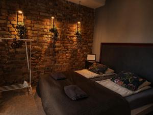 a bedroom with two beds and a brick wall at Flores Apartament in Katowice