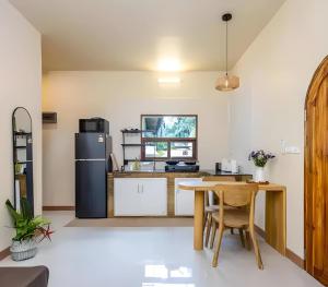 a kitchen with a table and a refrigerator at Villa Casa Blanca in Wok Tum +2 photos