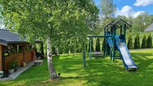 a playground in a yard with a tree at domki Stara Morawa in Stronie Śląskie