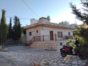 a motorcycle parked in front of a brick building at The Mountain Village View اطلالة الجبل in ‘Ibbīn