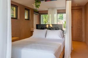 a bedroom with a large bed with white sheets at Nest In The Yard in Parga