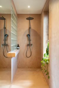 a walk in shower with two lights on the wall at Nest In The Yard in Parga