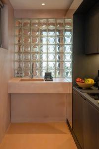a kitchen with a sink and a window with dishes at Nest In The Yard in Parga