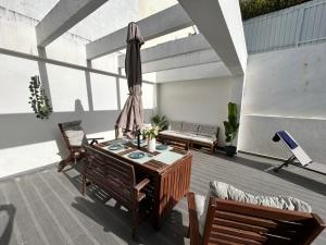 a patio with a table and chairs and an umbrella at Valadares Pool Villa in Corroios