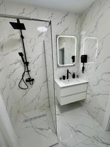 a white bathroom with a sink and a mirror at Apartament Bucovina Bellevue in Gura Humorului