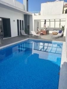 a large blue swimming pool in front of a house at Valadares Pool Villa in Corroios