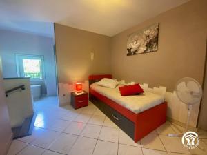 a small bedroom with a bed and a fan at La paraguère in Sorède