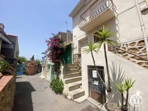 a building with stairs and flowers on the side of it at La paraguère in Sorède