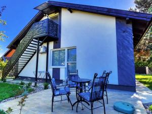 a patio with chairs and a table in front of a house at Apartman Dve lipe in Palić