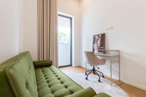 a living room with a green couch and a desk at ASTRO Emanuelle E by LovelyStay in Leça da Palmeira