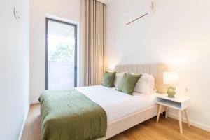 a white bedroom with a bed and a window at ASTRO Emanuelle E by LovelyStay in Leça da Palmeira