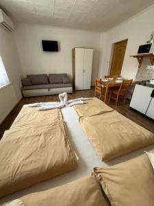two large beds in a room with a couch at Liliom Vendégház in Bakonybél