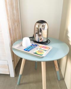 a table with a tea kettle and a magazine on it at Estrella in Les Sables-d'Olonne