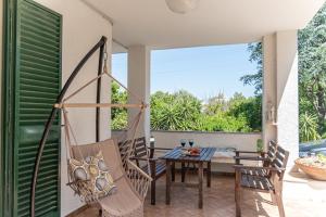 a patio with a table and chairs on a balcony at Pugliaholidayplus - IL VILLONE NEL BOSCO in Polignano a Mare