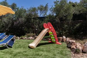 a plastic slide on the grass in a yard at Pugliaholidayplus - IL VILLONE NEL BOSCO in Polignano a Mare