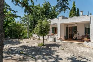 a white house with a tree in the yard at Pugliaholidayplus - IL VILLONE NEL BOSCO in Polignano a Mare