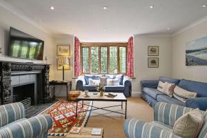 a living room with blue couches and a fireplace at Hockley House by Bloom Stays in Folkestone