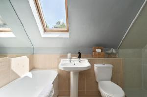 a bathroom with a sink and a toilet and a bath tub at Hockley House by Bloom Stays in Folkestone +29 photos