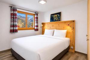 a bedroom with a large white bed and a window at Chalet Amerhone - Luxury chalet With Jacuzzi in Riddes