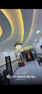 a living room with a ceiling with a chandelier at Sai Samarth Residency Akkalkot in Akalkot