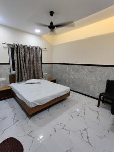 a bedroom with a bed and a ceiling fan at Sai Samarth Residency Akkalkot in Akalkot