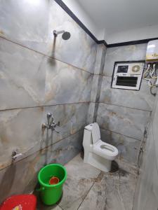 a bathroom with a toilet and a green bucket at Sai Samarth Residency Akkalkot in Akalkot +8 photos