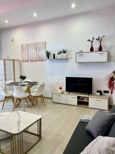 a living room with a television and a table and chairs at Rota Beach Loft in Rota