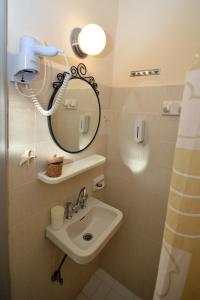ein Badezimmer mit Waschbecken und Spiegel in der Unterkunft Koukounari Rooms in Skala