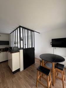 a room with a table and chairs and a kitchen at Studio with garden in Dinard
