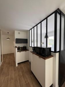 a kitchen with white cabinets and black accents at Studio with garden in Dinard +1 photo