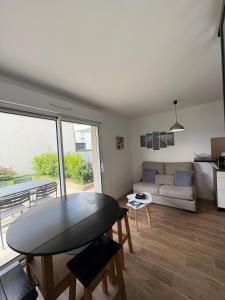 a living room with a table and a couch at Studio with garden in Dinard
