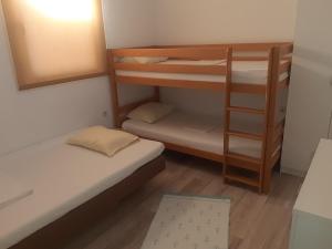 a small room with two bunk beds and a mirror at Apartman Almira in Donji Štoj